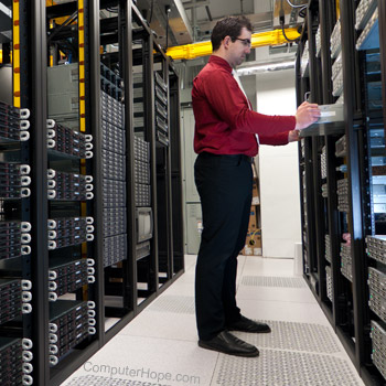 Computer administrator working in a server room.