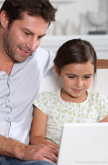 Parent over shoulder of girl on computer