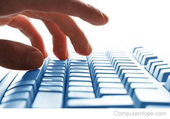 Person's hand pressing keyboard keys.