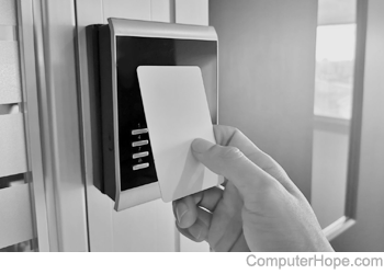 Person holding a keycard up to a security card reader.