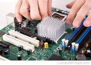 Hands working with a computer motherboard.